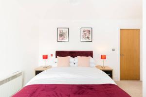 a white bedroom with a large bed with two lamps at Duplex 2 Bedroom Apartment In City Nites - Near Arena - 2 Bathroom - City Centre in Birmingham