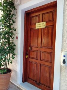 una puerta de madera con un cartel que dice hospital internacional en Mandaniki Apartments en Vassilias