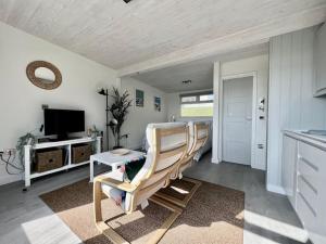 a living room with two chairs and a television at Little Haven, one bed chalet in Dartmouth, Devon in Dartmouth
