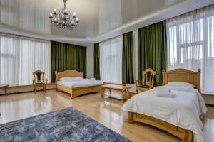 1 dormitorio con 2 camas y lámpara de araña en Mountain View Hot Spring Resort en Alamedin