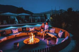 two people sitting on a couch next to a fire pit at Superior Sport und Familienresort Alpenblick in Zell am See