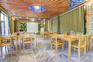 Mountain View Hot Spring Resort في Alamedin: قاعة اجتماعات مع طاولات وكراسي خشبية