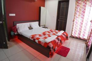 een slaapkamer met een bed met een rode muur bij Infinity Penthouse with Pool, Sauna, Gym in Rajkot +40 foto's