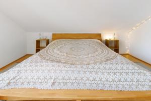 a bedroom with a bed with a blanket on it at Traum mit Seeblick in Allensbach