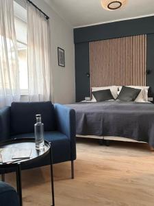 a bedroom with a bed and a blue couch and a table at Central Studio in Pécs
