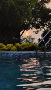 una piscina con puesta de sol en el fondo en Lalera stay, en Chāndawāri