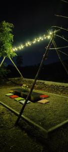 a swingiety with lights on it at night at Lalera stay in Chāndawāri