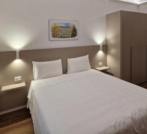 トリノにあるホテル ローマ エ ロッカ カヴールのベッドルーム1室(大きな白いベッド1台、枕2つ付)