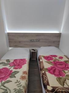 twee bedden naast elkaar in een kamer bij Alpha Hotel in Bouafle