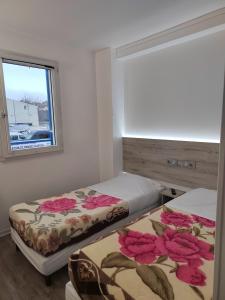 Duas camas num quarto com uma janela em Alpha Hotel em Bouafle