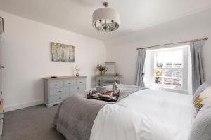 Habitación blanca con cama y ventana en Stableyard Apartment: Drumlanrig Castle, en Thornhill