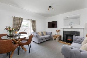 sala de estar con mesa y chimenea en Stableyard Apartment: Drumlanrig Castle en Thornhill