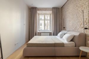 リヴィウにあるInshiApartments on Rynok Squareのベッドとレンガの壁がある寝室