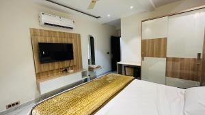 a bedroom with a bed and a flat screen tv at Hotel Katani Inn in Kharar