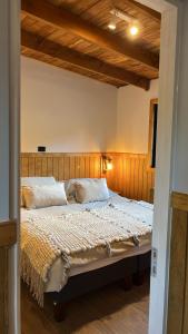 sypialnia z dużym łóżkiem z drewnianym zagłówkiem w obiekcie Wincarayen Lodge & Cabañas w mieście Panguipulli +62 zdjęcia