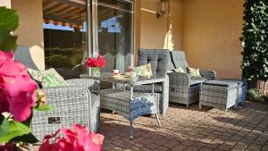 eine Terrasse mit Korbstühlen und einem Tisch mit in der Unterkunft Ferienwohnung Fasse in Delliehausen
