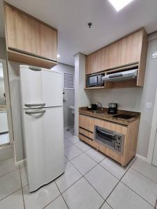 ブラジリアにあるAconcheganteのキッチン(白い冷蔵庫、コンロ付)