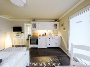 uma cozinha com armários brancos e uma cama num quarto em Friendly Home Doppel-Doppelappartement Union em Bornheim