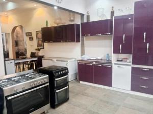 uma cozinha com armários roxos e um forno com placa de fogão em Mike Taylor's House em Tokuse