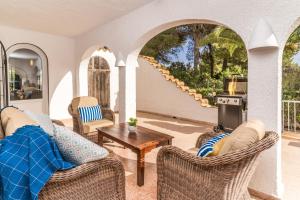 ein Wohnzimmer mit Stühlen, einem Tisch und einem Herd in der Unterkunft Casa Sundial in Balcon del Mar