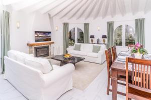 ein Wohnzimmer mit weißen Möbeln und einem Kamin in der Unterkunft Casa Sundial in Balcon del Mar