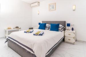 ein Schlafzimmer mit einem großen Bett mit blauen Kissen in der Unterkunft Casa Sundial in Balcon del Mar + 42 Fotos