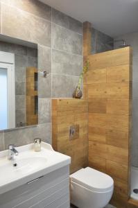 uma casa de banho com um lavatório branco e um WC. em Thess1home Apartments em Tessalónica