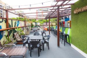 an outdoor patio with tables and chairs and plants at El Misti Hostel Ipanema in Rio de Janeiro