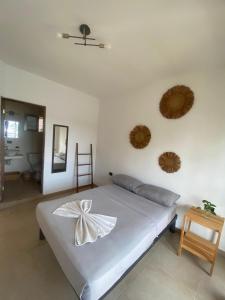 a bedroom with a bed with a bow on it at 3B Wellness Hostel in Playa del Carmen