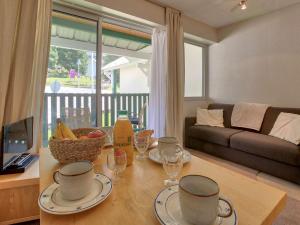 a living room with a table with glasses and a couch at Appartement confortable 4 pers avec balcon et casier à skis à Gourette - FR-1-400-114 in Eaux-Bonnes