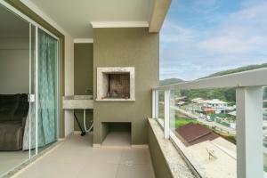 a room with a balcony with a view at Aluguel Apartamento 3 Quartos s 1 Suite Bombas in Bombas