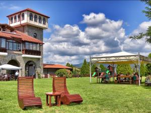 two chairs and a table in a yard with a building at Popova Kula Hotel & Winery in Demir Kapija