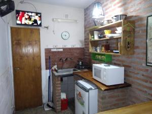 a small kitchen with a sink and a microwave at Los Duendes del Mar in San Clemente del Tuyú