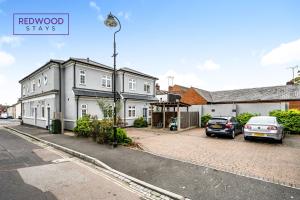 a street view of a house with cars parked on the street at Brand New 1 Bed 1 Bath, Modern Town Center Apartment, Netflix By Redwood Stays in Aldershot +12 photos