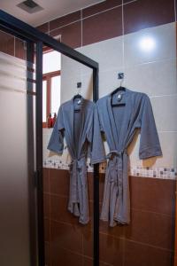 twoimonos hanging on a rack in a bathroom at Piedra Negra Boutique Hotel in San Cristóbal de Las Casas