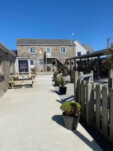 a building with a wooden fence and some benches at Bushwood-Beautifully Fitted Wooden Lodge Helston Cornwall in Helston