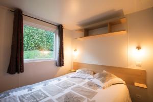 1 dormitorio con cama y ventana en CAMPING LA CLE DE SAONE en Crêches-sur-Saône