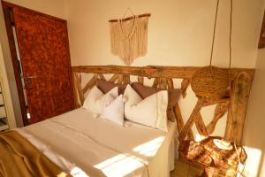a bedroom with a bed with white sheets and pillows at Casa Örüm in Florianópolis