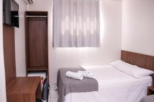 a small room with a bed with towels on it at Palace Hotel in Bom Jesus da Lapa