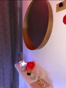 ein Spiegel an einer Wand über einem Tisch mit einer Tastatur in der Unterkunft So'Spa appart' jacuzzi & bien-être in Lingolsheim