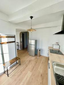 Habitación con cocina y suelo de madera. en Appartement ensoleillé Manosque, en Manosque