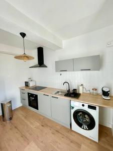 a kitchen with a sink and a washing machine at Appartement ensoleillé Manosque in Manosque