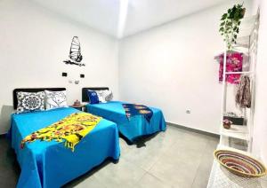 een slaapkamer met 2 bedden in een kamer bij Animos! Apartments - 10 modern apartments near the city & beach, perfect for nomads, travellers, families, watersports! in Santa Maria