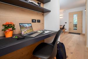 ein Büro mit einem Schreibtisch mit einem Laptop und einem Stuhl in der Unterkunft Casa Paolina - Alpine Stay Apartments in Tesero