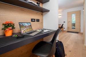 una oficina con un escritorio con una computadora portátil y una silla en Casa Paolina - Alpine Stay Apartments, en Tesero