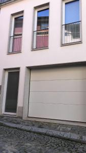 une paire de portes de garage sur un bâtiment blanc dans l'établissement Casa Augusta 4, à Braga