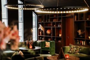 a room with couches and tables and a chandelier at Clarion Hotel Grand Östersund in Östersund