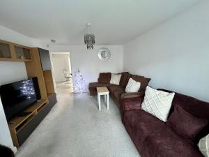 uma sala de estar com um sofá e uma televisão em Beautiful 4-Bedroom House with Private Garden & Parking em Edimburgo