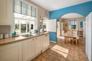 a kitchen with a sink and a table in a room at Solenta in Yarmouth