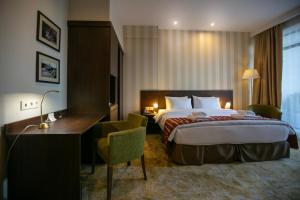 a hotel room with a bed and a desk at Citrus Hotel in Tbilisi City